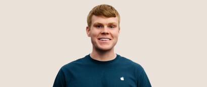 Portrait d’une personne de l’équipe de vente au détail d’Apple souriant; elle a des cheveux blond foncé courts.